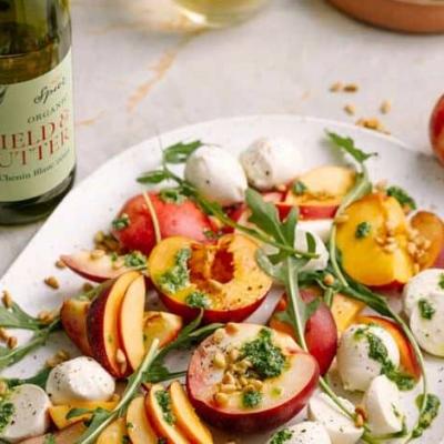 Stone fruit Caprese salad with bocconcini and basil pesto drizzle